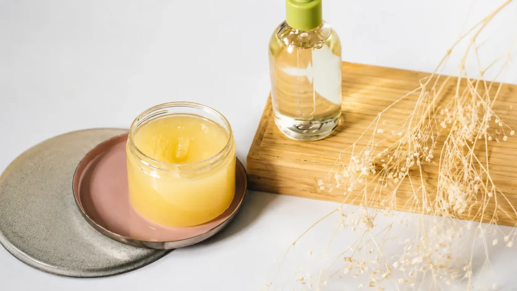 Natural body butter and skincare serum displayed on a minimalist surface, featuring moisturizing beauty products for healthy skin care