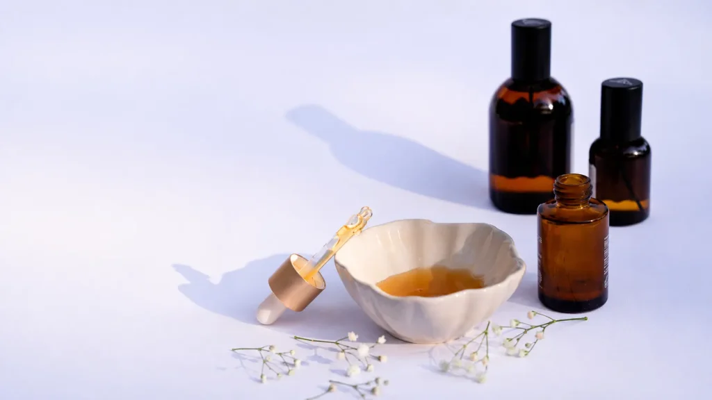 Natural skincare serum with essential oil bottles, dropper, and organic beauty ingredients on a clean minimalist background.